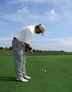 Golfer putting in the wind